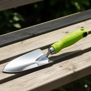 Ein neuer, sauberer handspaten ergonomisch mit einem farbenfrohen, bequemen Griff auf einer Holzbank.